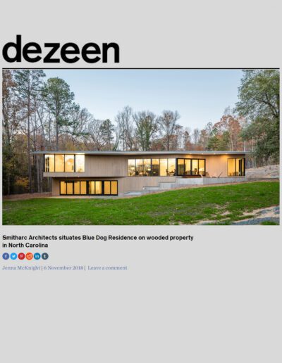 Modern blue dog residence by smitharc architects nestled in a north carolina forest at dusk.