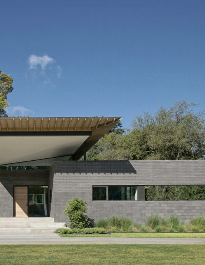 A modern single-story house with a large overhanging roof and extensive use of concrete and glass.